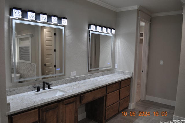 bathroom featuring wood-type flooring, vanity, and crown molding