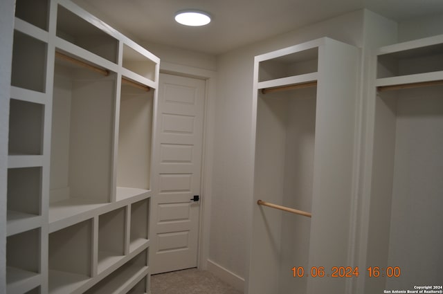 walk in closet featuring light colored carpet