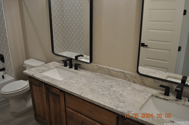 full bathroom featuring hardwood / wood-style flooring, vanity, toilet, and shower / tub combination