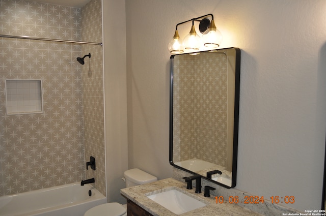 full bathroom with vanity, tiled shower / bath combo, and toilet