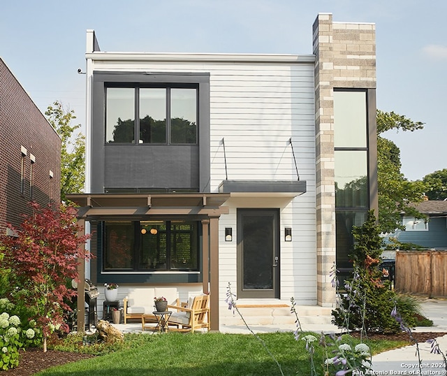 view of front of home with outdoor lounge area, a patio area, and a front yard