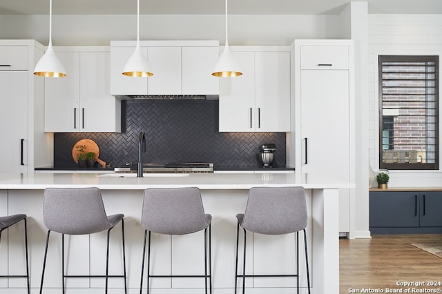 kitchen with tasteful backsplash, a kitchen bar, and hanging light fixtures