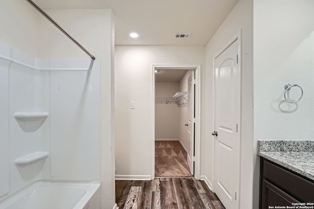 bathroom with hardwood / wood-style floors, vanity, and shower / washtub combination