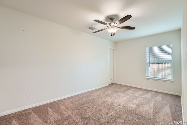 carpeted spare room featuring ceiling fan