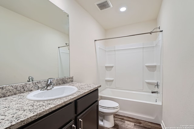 full bathroom with vanity, toilet, washtub / shower combination, and hardwood / wood-style flooring