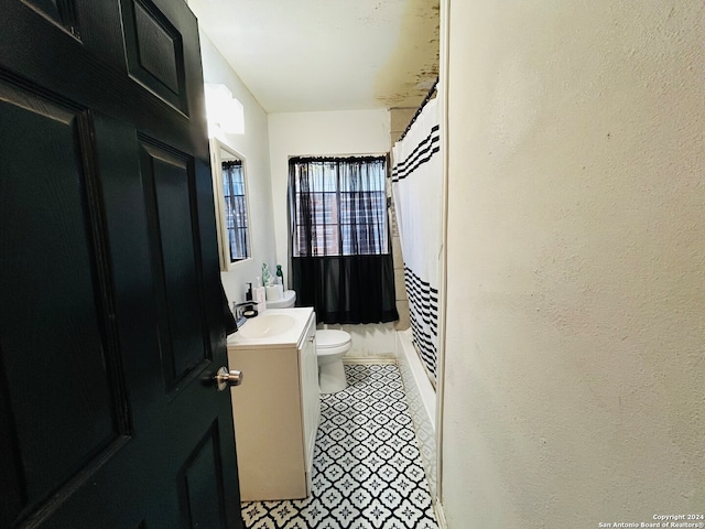 bathroom featuring tile patterned floors, vanity, and toilet