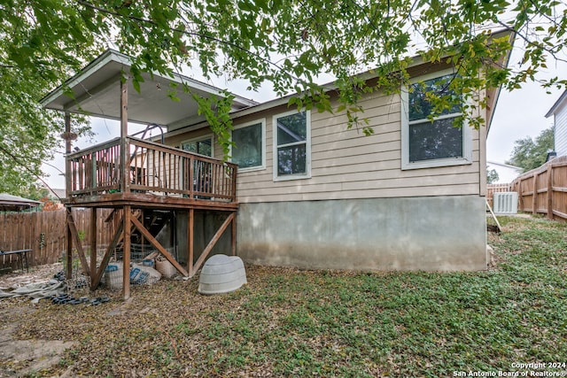 rear view of house with a deck and cooling unit