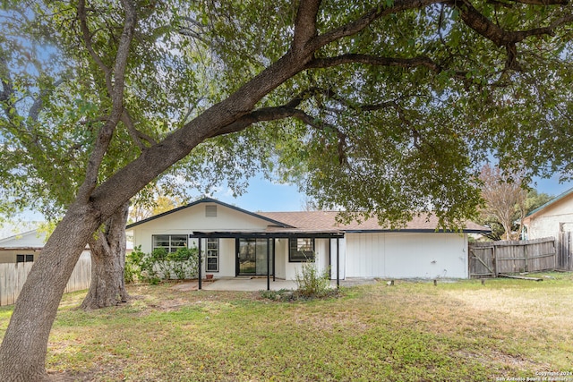 rear view of house featuring a lawn and a patio area