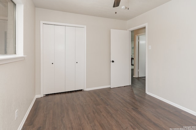 unfurnished bedroom featuring ceiling fan, a closet, and dark wood-type flooring