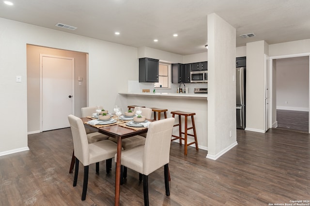 dining space with sink and dark wood-type flooring