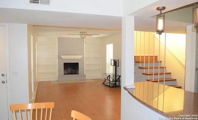 living room with ceiling fan, a fireplace, and hardwood / wood-style flooring