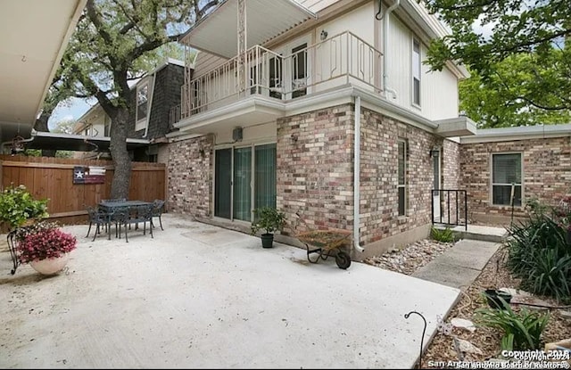 rear view of property with a balcony and a patio