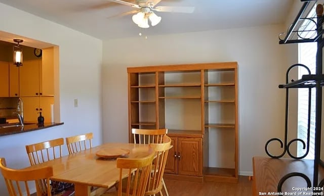 dining space featuring ceiling fan, hardwood / wood-style flooring, and sink