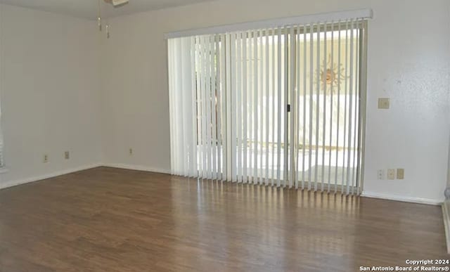 unfurnished room with ceiling fan and dark wood-type flooring