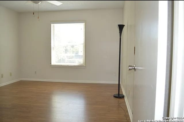 empty room with ceiling fan and wood-type flooring