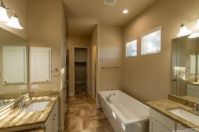 bathroom featuring vanity and a bath