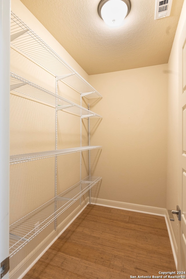 spacious closet featuring hardwood / wood-style flooring