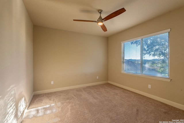 spare room featuring light carpet and ceiling fan