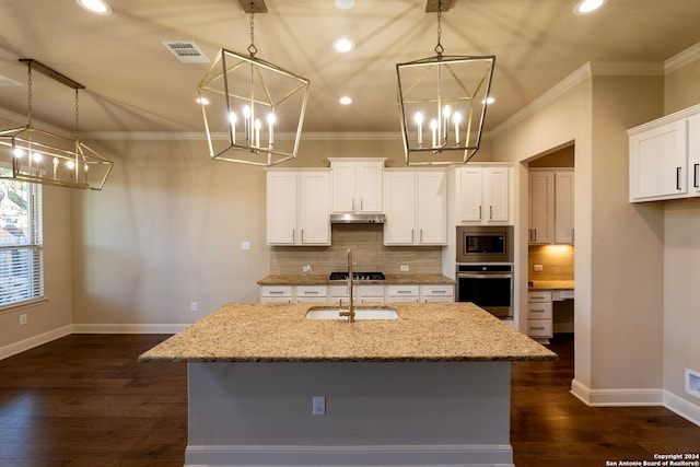 kitchen featuring light stone countertops, appliances with stainless steel finishes, dark hardwood / wood-style flooring, white cabinets, and an island with sink