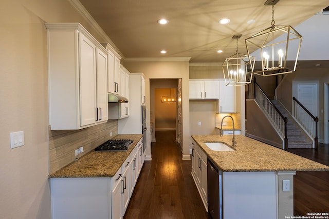 kitchen with stainless steel appliances, sink, pendant lighting, stone countertops, and white cabinets