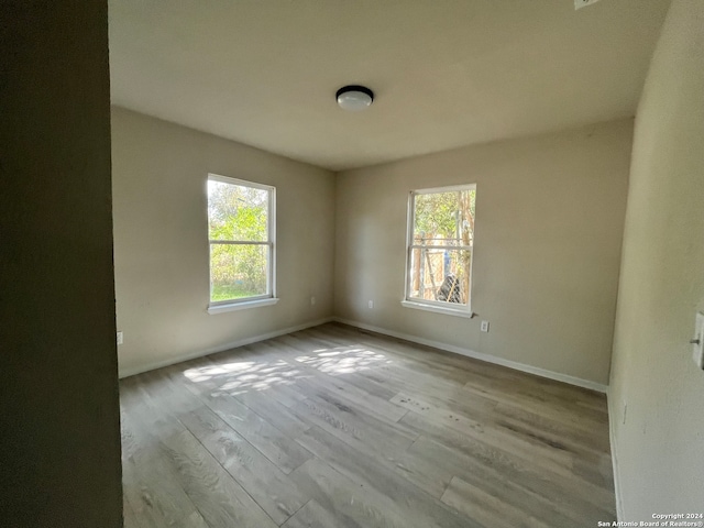 empty room featuring plenty of natural light and light hardwood / wood-style floors