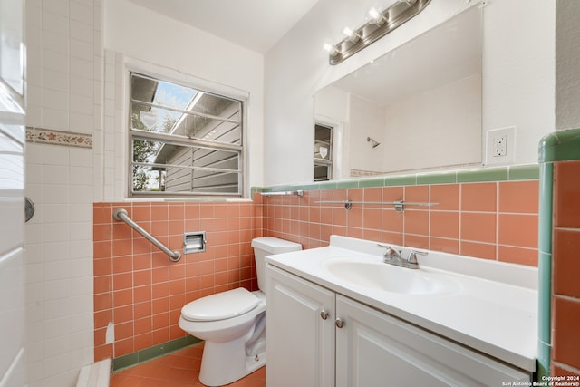 bathroom featuring tile patterned flooring, vanity, toilet, and tile walls