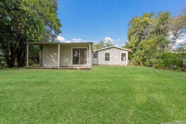 rear view of property with a yard