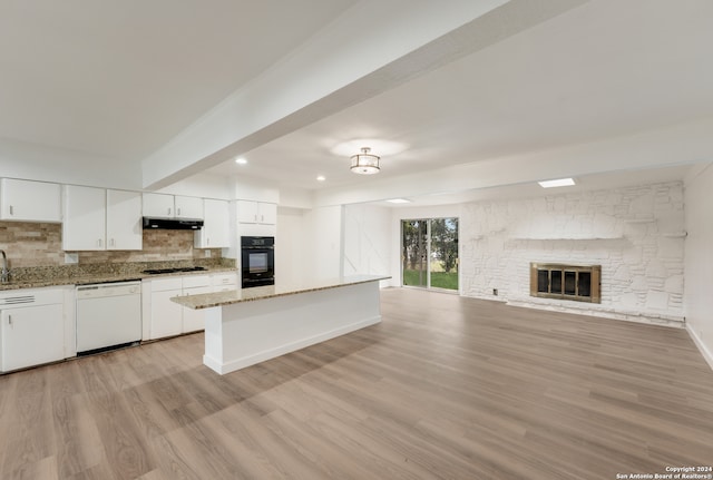 kitchen featuring dishwasher, gas cooktop, black oven, white cabinets, and light wood-type flooring