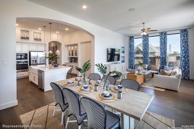 dining room with dark wood-type flooring, ceiling fan, and sink