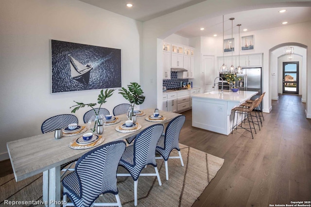 dining area featuring sink and dark wood-type flooring