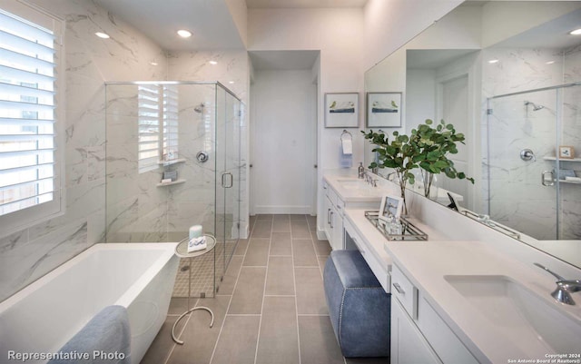 bathroom with tile patterned floors, plenty of natural light, plus walk in shower, and vanity