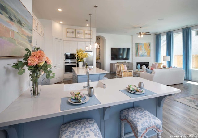 kitchen with stainless steel appliances, a large island, a kitchen breakfast bar, and decorative light fixtures