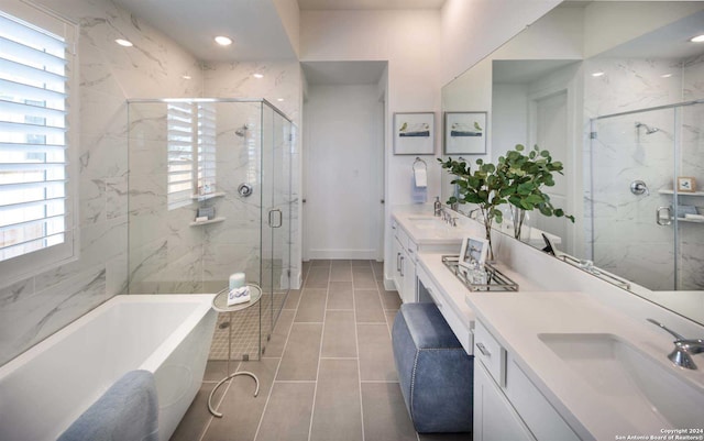 bathroom with tile patterned floors, plenty of natural light, independent shower and bath, and vanity