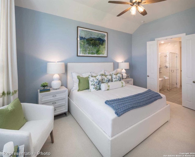 bedroom featuring ceiling fan, vaulted ceiling, and ensuite bath