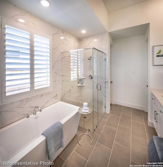 bathroom with tile patterned flooring, vanity, and separate shower and tub