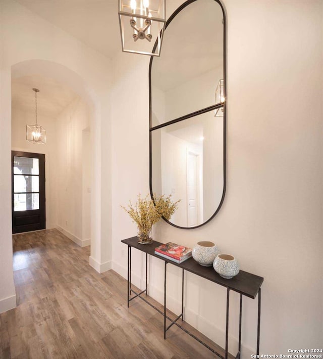 foyer entrance featuring hardwood / wood-style flooring and a notable chandelier