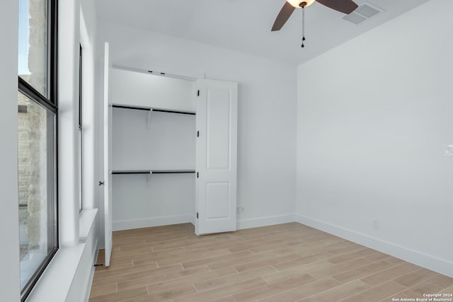 unfurnished bedroom with ceiling fan, a closet, and light hardwood / wood-style floors