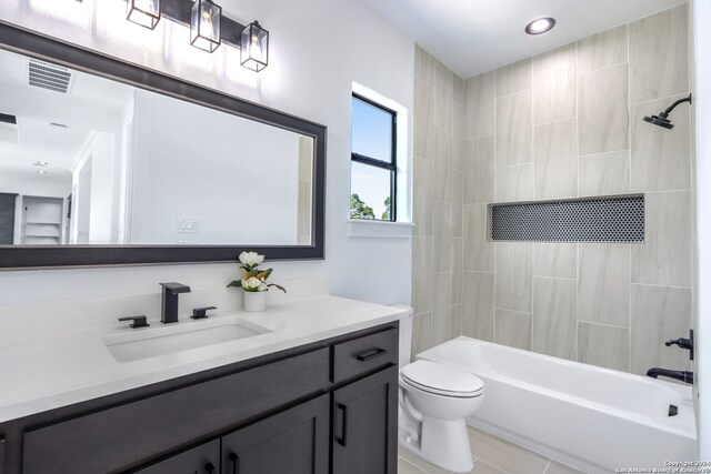 full bathroom with vanity, tiled shower / bath, and toilet