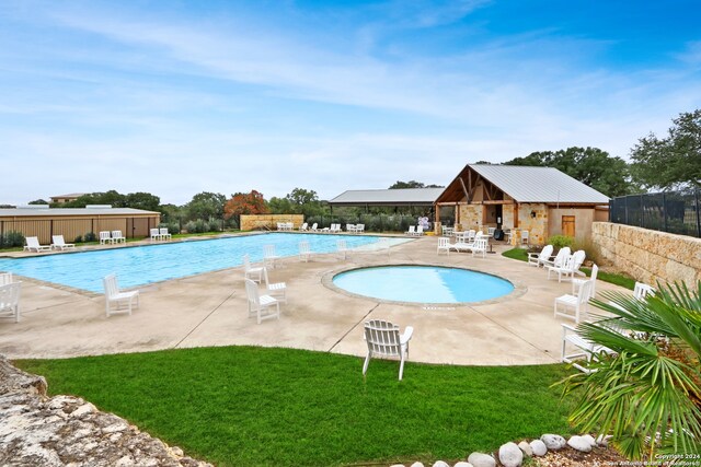 view of swimming pool with a lawn and a patio