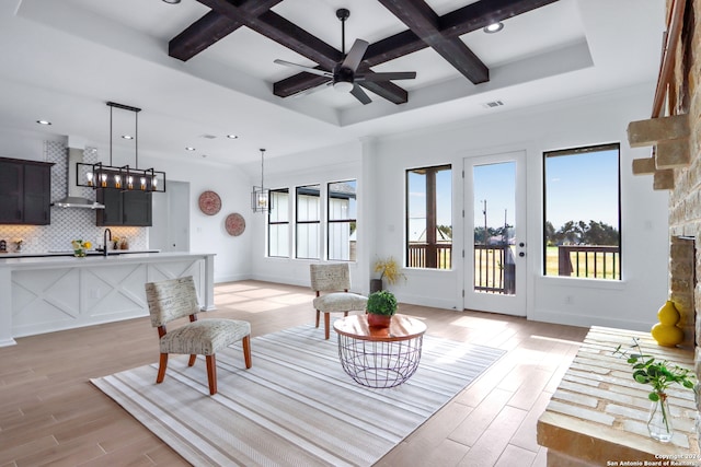 living room featuring coffered ceiling, sink, light hardwood / wood-style flooring, ceiling fan, and beam ceiling