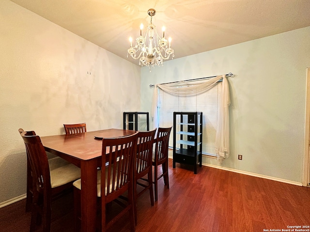 dining space featuring dark hardwood / wood-style floors and an inviting chandelier