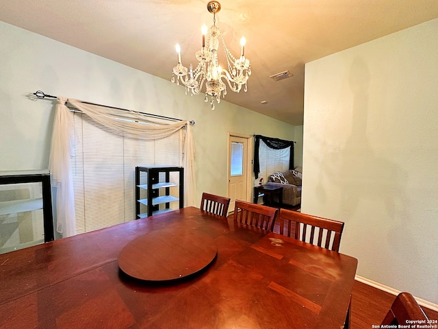 dining room with hardwood / wood-style floors and a notable chandelier