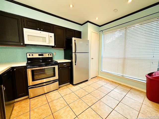 kitchen with tasteful backsplash, ornamental molding, dark brown cabinetry, stainless steel appliances, and light tile patterned floors