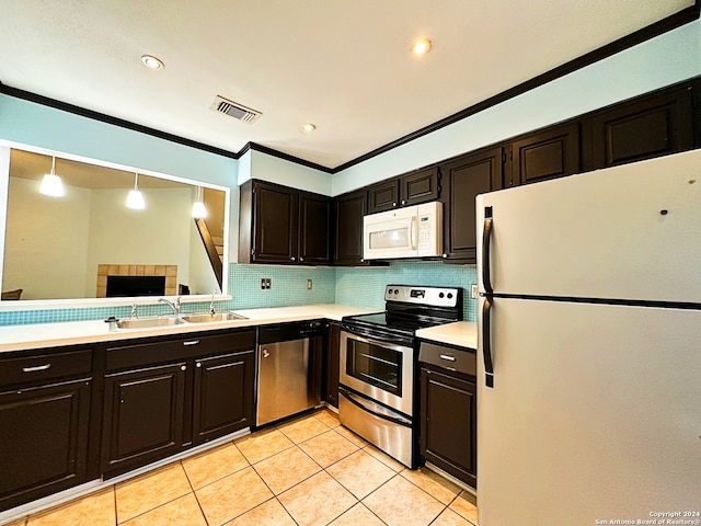 kitchen with appliances with stainless steel finishes, backsplash, crown molding, sink, and hanging light fixtures