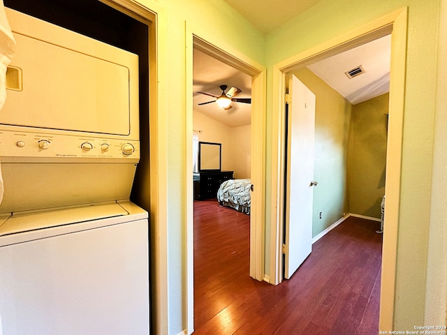 laundry area with ceiling fan, dark wood-type flooring, and stacked washer and clothes dryer