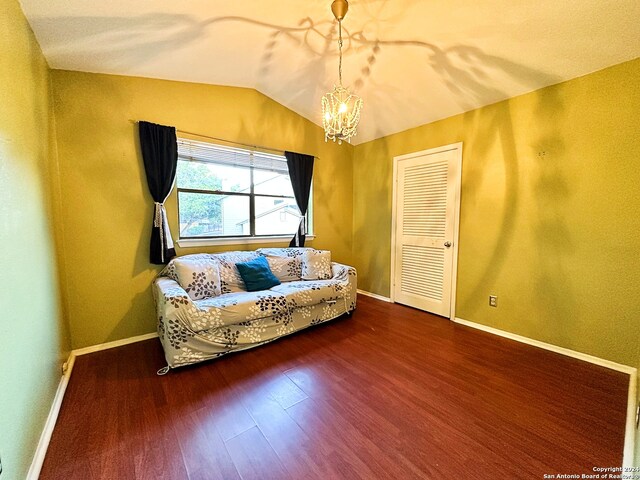 sitting room featuring hardwood / wood-style floors, a notable chandelier, and lofted ceiling