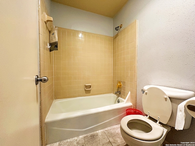 bathroom featuring toilet and tiled shower / bath