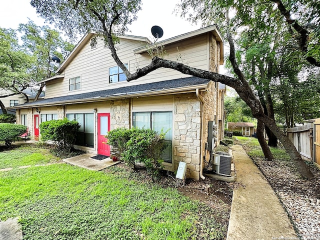 rear view of house with a lawn and cooling unit