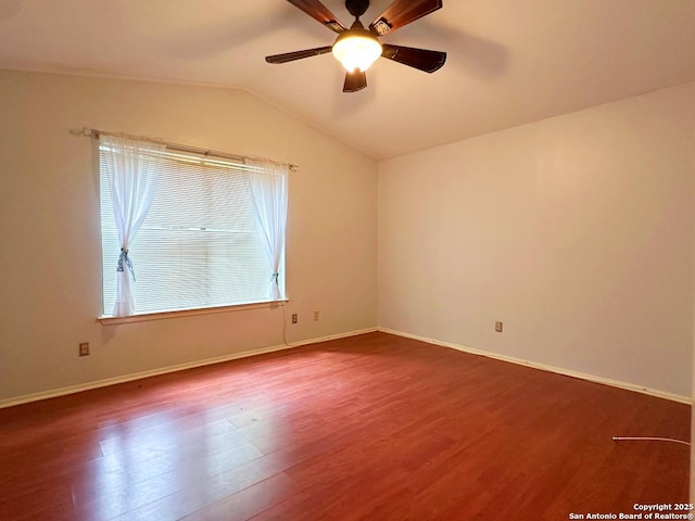 spare room with wood finished floors, a ceiling fan, vaulted ceiling, and baseboards