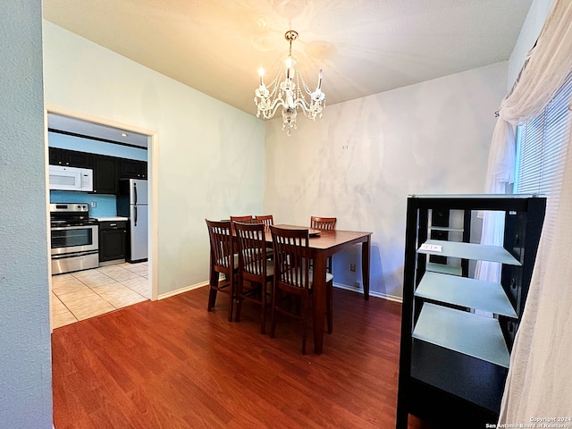 dining room with light hardwood / wood-style floors and a chandelier